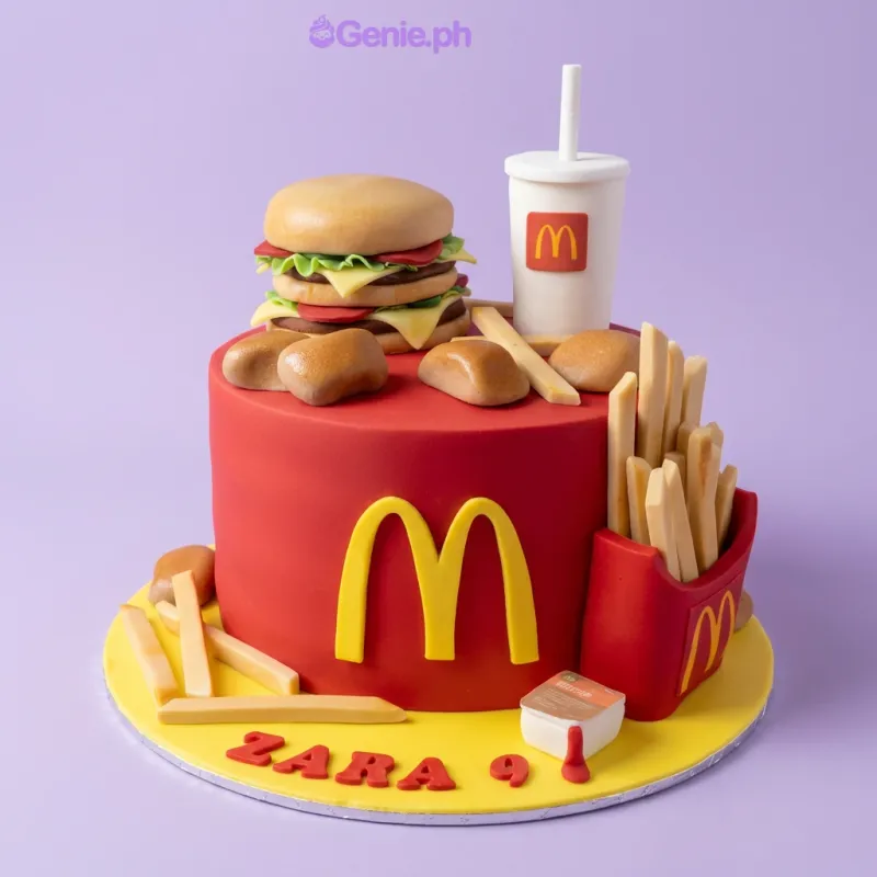 A red and yellow 1 Tier Fondant cake, McDonald's themed, with burger, fries, soda cup, and 'ZARA 9' text. A red and yellow 1 Tier Fondant cake, McDonald's themed, with burger, fries, soda cup, and 'ZARA 9' text.