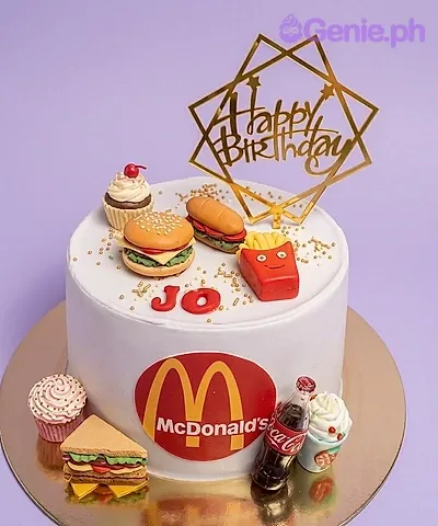 A white 1-tier cake themed around McDonald's, featuring fondant burger, fries, hotdog, and a gold Happy Birthday topper. A white 1-tier cake themed around McDonald's, featuring fondant burger, fries, hotdog, and a gold Happy Birthday topper.