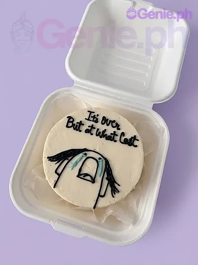 A white bento cake themed around memes, featuring a hand-drawn crying meme character and black icing text 'It's over But at what cost'. A white bento cake themed around memes, featuring a hand-drawn crying meme character and black icing text 'It's over But at what cost'.