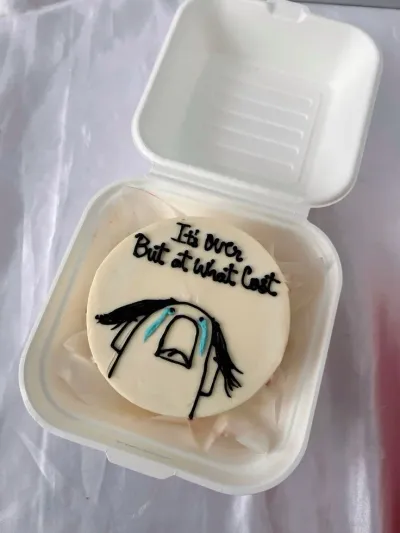 A white Bento cake themed around memes, featuring a hand-drawn crying character with blue tears and black text. A white Bento cake themed around memes, featuring a hand-drawn crying character with blue tears and black text.