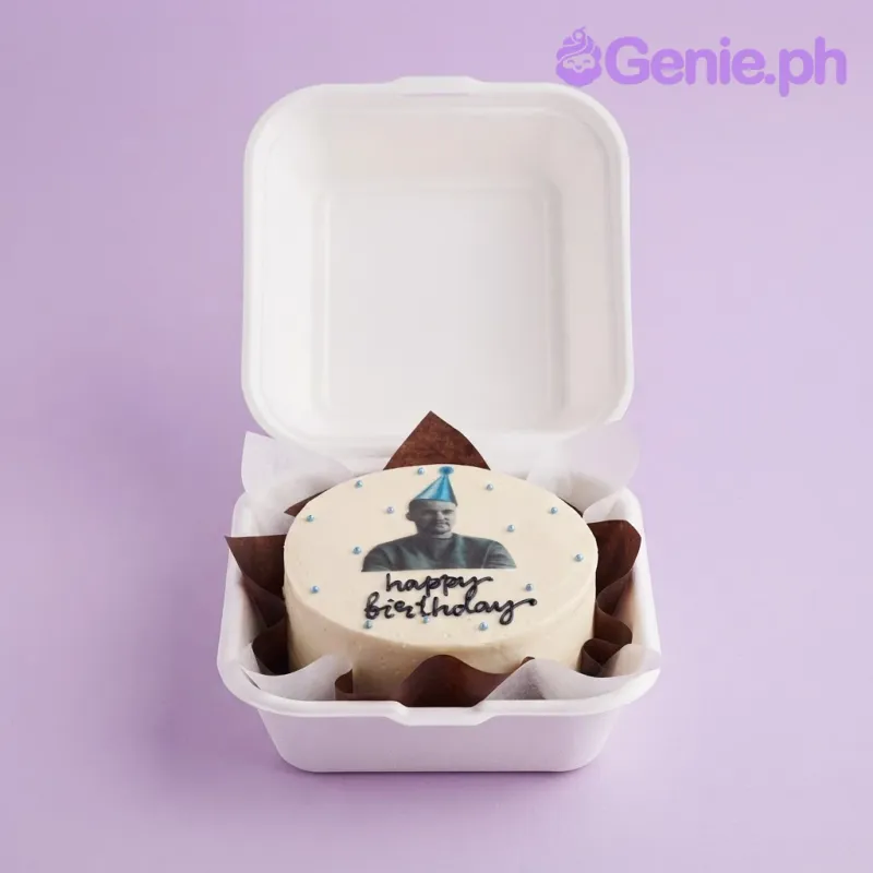 Ivory bento cake with smooth soft icing, an edible photo portrait with a blue party hat, and blue piped dots Ivory bento cake with smooth soft icing, an edible photo portrait with a blue party hat, and blue piped dots
