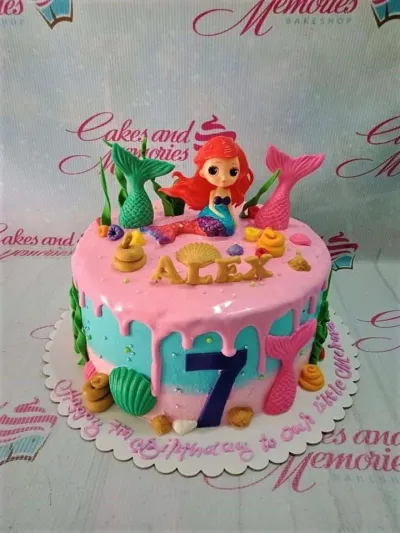A light blue and pink 1-tier cake themed around Mermaid Ariel, featuring an Ariel figure, mermaid tails, and fondant sea elements. A light blue and pink 1-tier cake themed around Mermaid Ariel, featuring an Ariel figure, mermaid tails, and fondant sea elements.