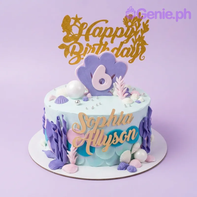 A light blue 1-tier Mermaid cake with a gold glitter Happy Birthday topper, a purple shell with number 6, and various seashells. A light blue 1-tier Mermaid cake with a gold glitter Happy Birthday topper, a purple shell with number 6, and various seashells.