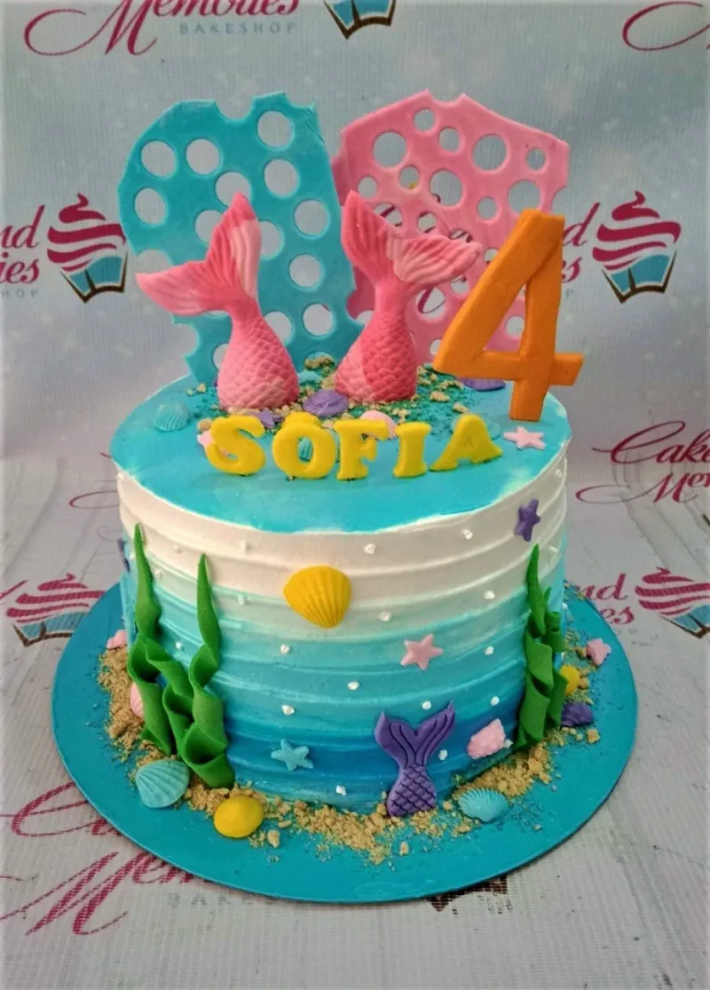 A multi-colored 1 Tier Mermaid cake, featuring pink mermaid tails, an orange '4', and yellow 'SOFIA' text. A multi-colored 1 Tier Mermaid cake, featuring pink mermaid tails, an orange '4', and yellow 'SOFIA' text.