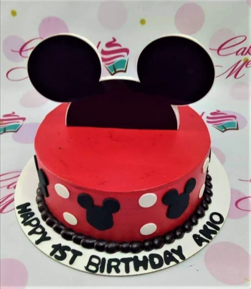 Red Mickey Mouse themed birthday cake with black Mickey silhouettes, white polka dots, and a large Mickey ear topper. Red Mickey Mouse themed birthday cake with black Mickey silhouettes, white polka dots, and a large Mickey ear topper.