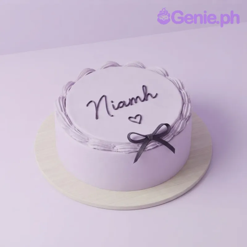 Lavender bento cake with smooth soft icing, piped border, black script lettering, a small heart, and a black ribbon bow Lavender bento cake with smooth soft icing, piped border, black script lettering, a small heart, and a black ribbon bow