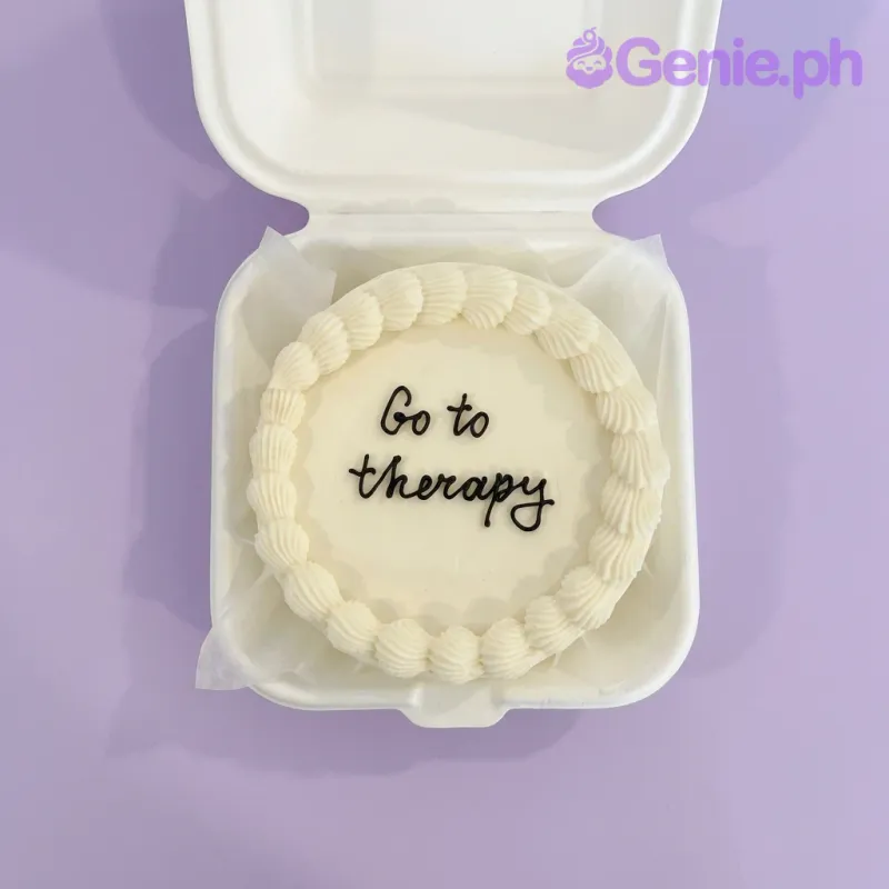 A white and cream Bento cake themed around a supportive message, featuring "Go to therapy" text and cream shell borders. A white and cream Bento cake themed around a supportive message, featuring "Go to therapy" text and cream shell borders.
