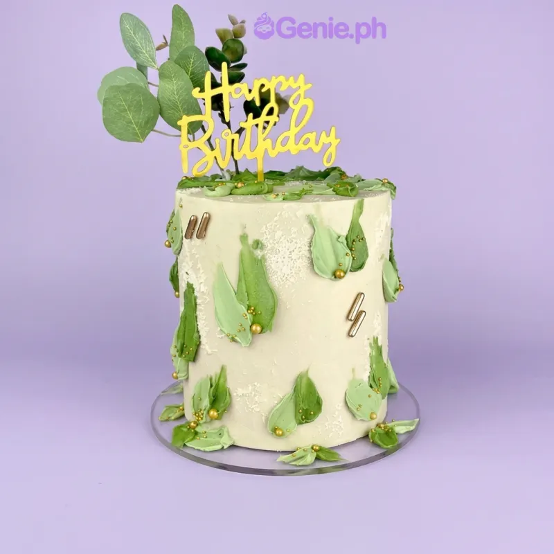 Beige 1-tier birthday cake with gold Happy Birthday topper and green eucalyptus leaves Beige 1-tier birthday cake with gold Happy Birthday topper and green eucalyptus leaves