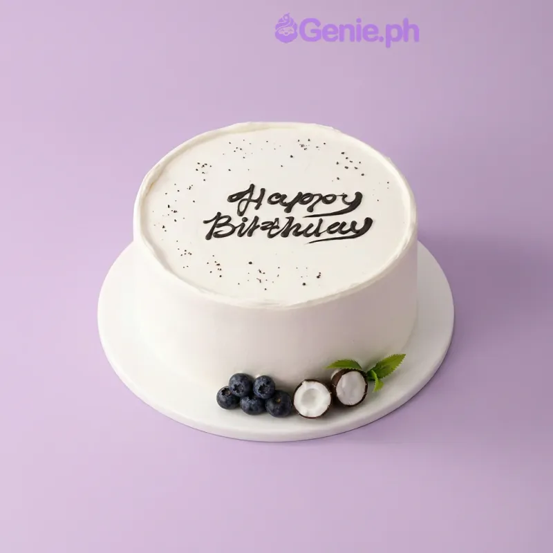 Minimalist white round birthday cake with Happy Birthday message in dark icing on a white cake board Minimalist white round birthday cake with Happy Birthday message in dark icing on a white cake board