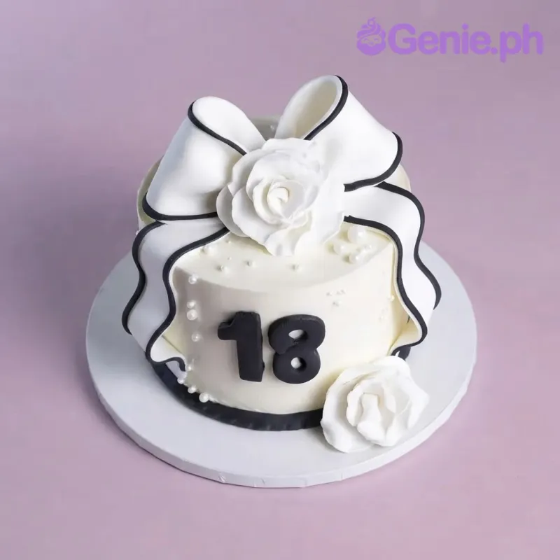 White 1-tier cake with smooth soft icing, a large white fondant bow with black trim, white fondant roses, and a black 18 age topper White 1-tier cake with smooth soft icing, a large white fondant bow with black trim, white fondant roses, and a black 18 age topper