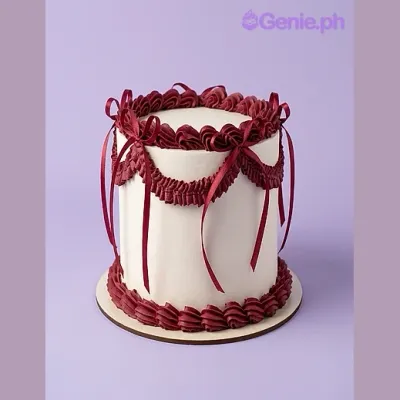 White single-tier cake with dark red piped borders, swags, and satin ribbon bows White single-tier cake with dark red piped borders, swags, and satin ribbon bows
