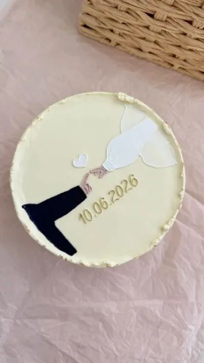 Pale yellow 1-tier cake with soft icing, minimalist couple theme, and flat fondant hand artwork Pale yellow 1-tier cake with soft icing, minimalist couple theme, and flat fondant hand artwork