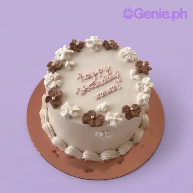 A white 1-Tier Minimalist Floral cake, featuring brown and white piped icing flowers and a pink 'happy birthday mom!' message. A white 1-Tier Minimalist Floral cake, featuring brown and white piped icing flowers and a pink 'happy birthday mom!' message.