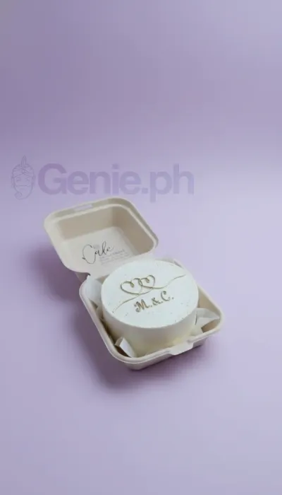 A white and gold Bento cake with a minimalist gold theme, featuring gold initials M and C, and gold heart line art. A white and gold Bento cake with a minimalist gold theme, featuring gold initials M and C, and gold heart line art.