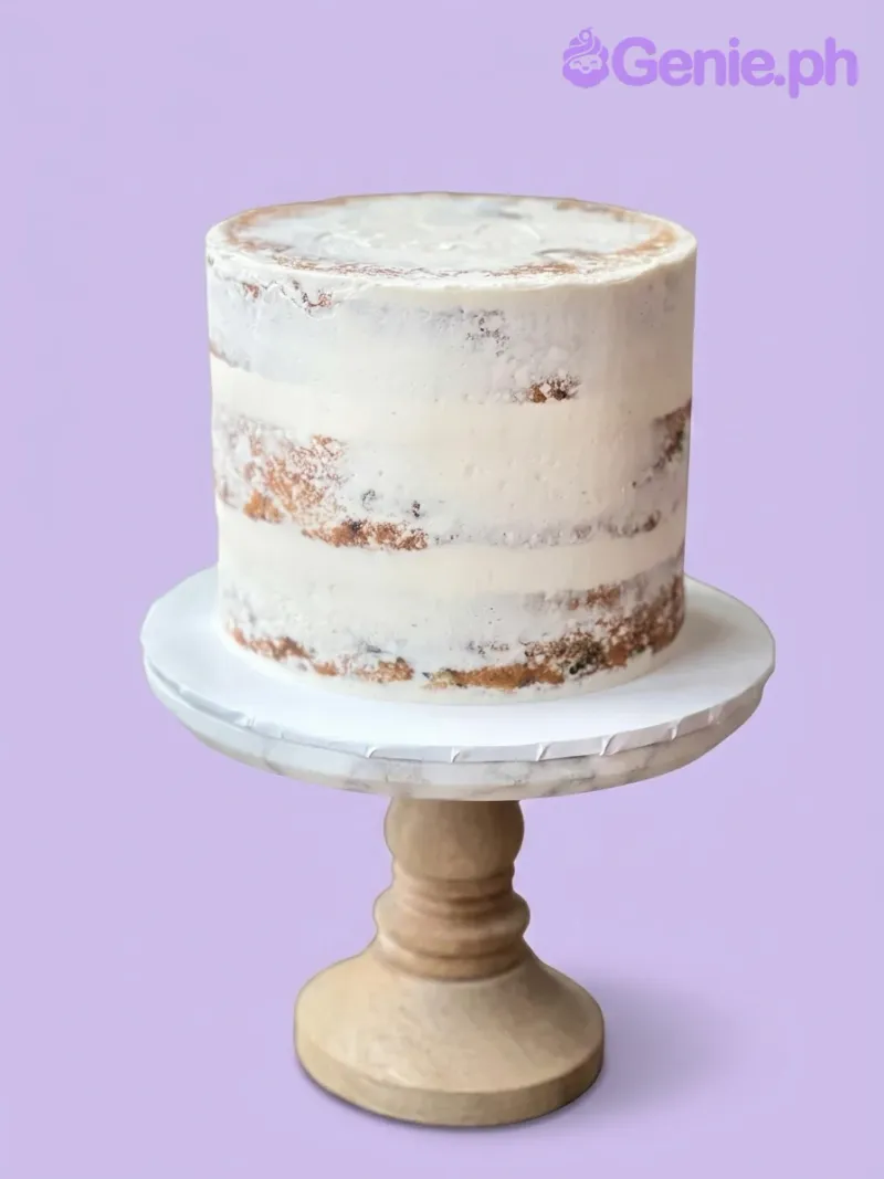 A white 1-tier cake themed around Minimalist White, featuring semi-naked soft icing revealing cake layers on a wooden stand. A white 1-tier cake themed around Minimalist White, featuring semi-naked soft icing revealing cake layers on a wooden stand.