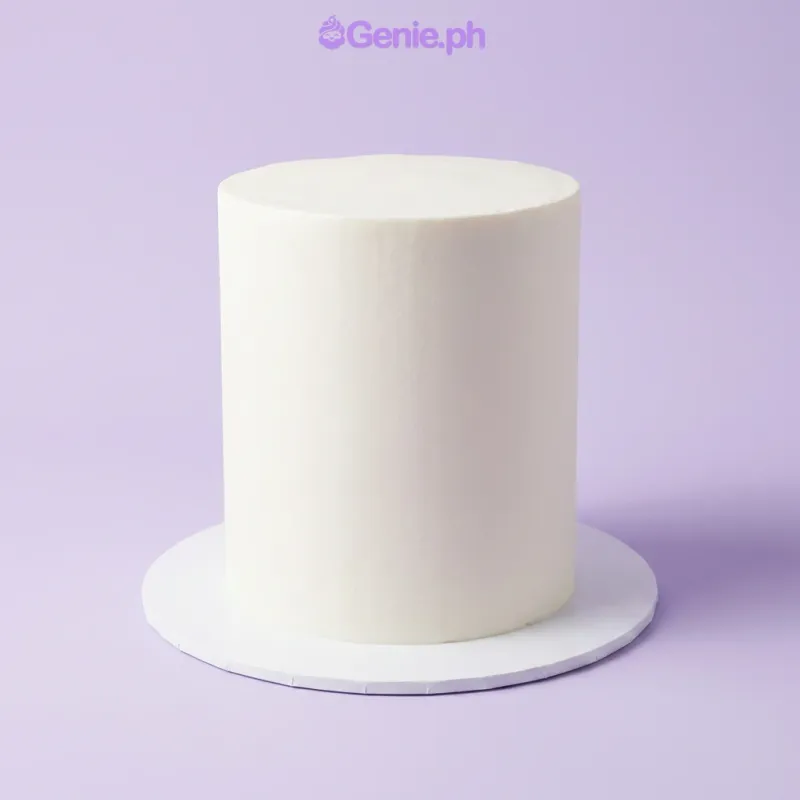 White single-tier cake on a cake stand being smoothed with a metal spatula White single-tier cake on a cake stand being smoothed with a metal spatula