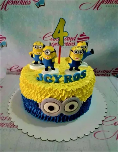 A yellow and blue 1-tier Minion cake, featuring four Minion figures, a yellow number 4 topper, and a Minion eye detail. A yellow and blue 1-tier Minion cake, featuring four Minion figures, a yellow number 4 topper, and a Minion eye detail.