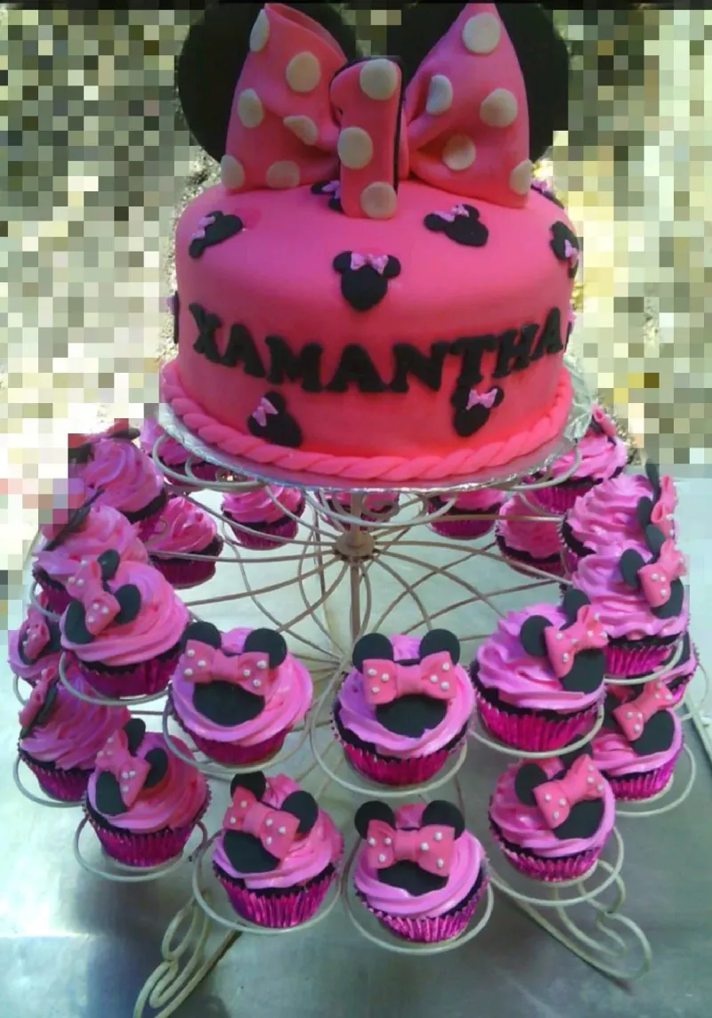 A pink Minnie Mouse fondant cake with a large pink polka dot bow, number one topper, and black mouse silhouettes. A pink Minnie Mouse fondant cake with a large pink polka dot bow, number one topper, and black mouse silhouettes.