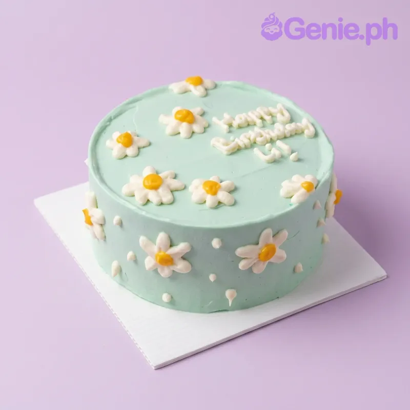 A mint green and white 1-tier cake themed with daisies, featuring white and yellow icing daisies and 'Happy Birthday Lil!' text. A mint green and white 1-tier cake themed with daisies, featuring white and yellow icing daisies and 'Happy Birthday Lil!' text.