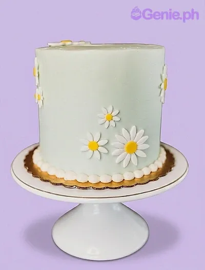 A mint green tall 1-tier cake themed around Mint Daisy, featuring white and yellow fondant daisies and a white pearl border on a gold board. A mint green tall 1-tier cake themed around Mint Daisy, featuring white and yellow fondant daisies and a white pearl border on a gold board.