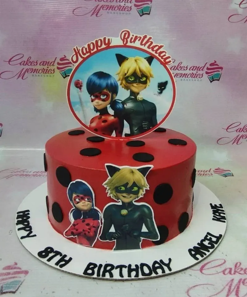 A red 1-Tier Miraculous Ladybug cake, featuring Ladybug and Cat Noir character toppers and black polka dots. A red 1-Tier Miraculous Ladybug cake, featuring Ladybug and Cat Noir character toppers and black polka dots.