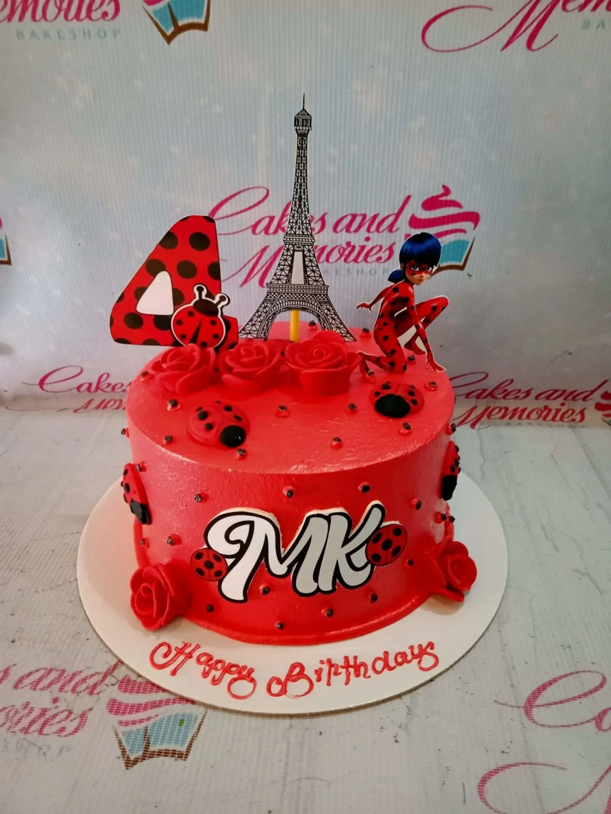 A red and white 1 Tier Miraculous Ladybug cake featuring Ladybug, Eiffel Tower, a number 4, red roses, and fondant ladybugs. A red and white 1 Tier Miraculous Ladybug cake featuring Ladybug, Eiffel Tower, a number 4, red roses, and fondant ladybugs.