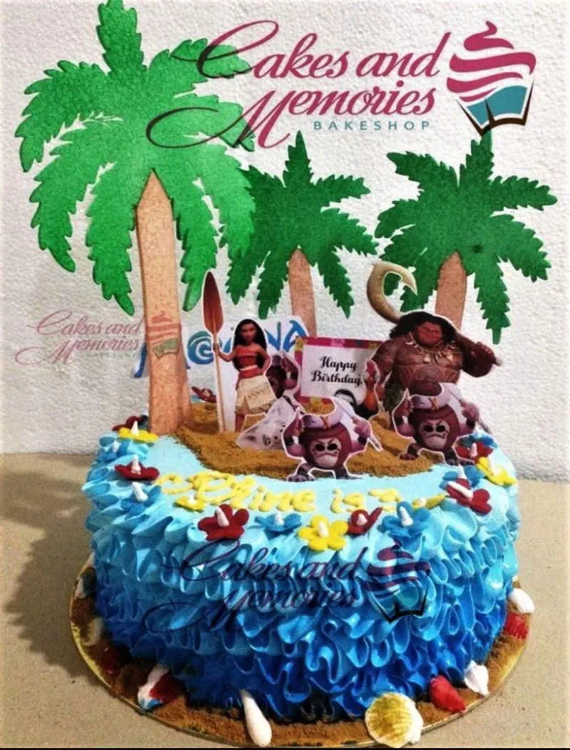 A blue and sandy 1 Tier cake themed around Moana, featuring character and palm tree toppers, ruffled icing, and seashells. A blue and sandy 1 Tier cake themed around Moana, featuring character and palm tree toppers, ruffled icing, and seashells.