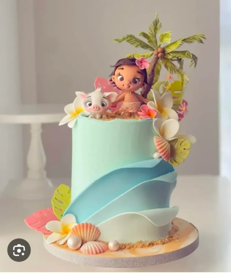 Light blue 1-tier cake with fondant wave ruffles, Moana and Pua figurines, a palm tree, and tropical flowers Light blue 1-tier cake with fondant wave ruffles, Moana and Pua figurines, a palm tree, and tropical flowers