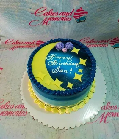Blue and yellow moon and stars themed birthday cake with purple icing flowers and a personalized message. Blue and yellow moon and stars themed birthday cake with purple icing flowers and a personalized message.
