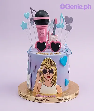 Lavender gradient 1-tier cake with a Taylor Swift character printout, 3D microphone, guitar, and heart sunglasses toppers. Lavender gradient 1-tier cake with a Taylor Swift character printout, 3D microphone, guitar, and heart sunglasses toppers.