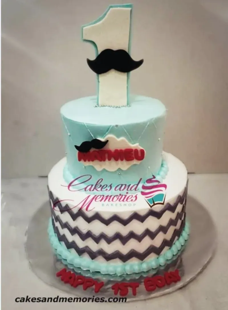 A light blue and white fondant cake for a Mustache 1st Birthday, with mustache and number one toppers, and chevron patterns. A light blue and white fondant cake for a Mustache 1st Birthday, with mustache and number one toppers, and chevron patterns.