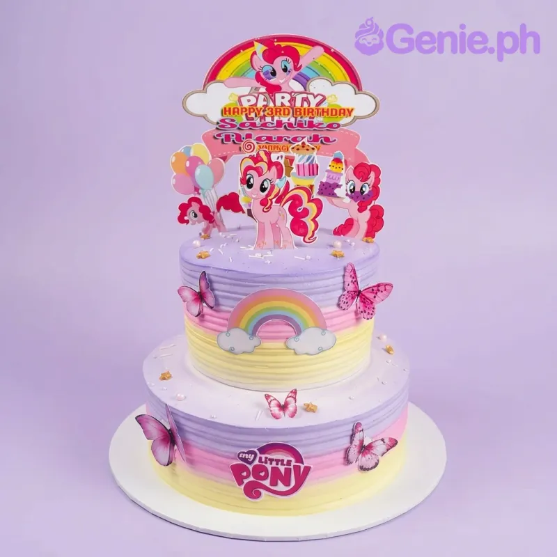 A purple and yellow gradient two-tier cake themed around My Little Pony, featuring Pinkie Pie character toppers and rainbow printouts. A purple and yellow gradient two-tier cake themed around My Little Pony, featuring Pinkie Pie character toppers and rainbow printouts.