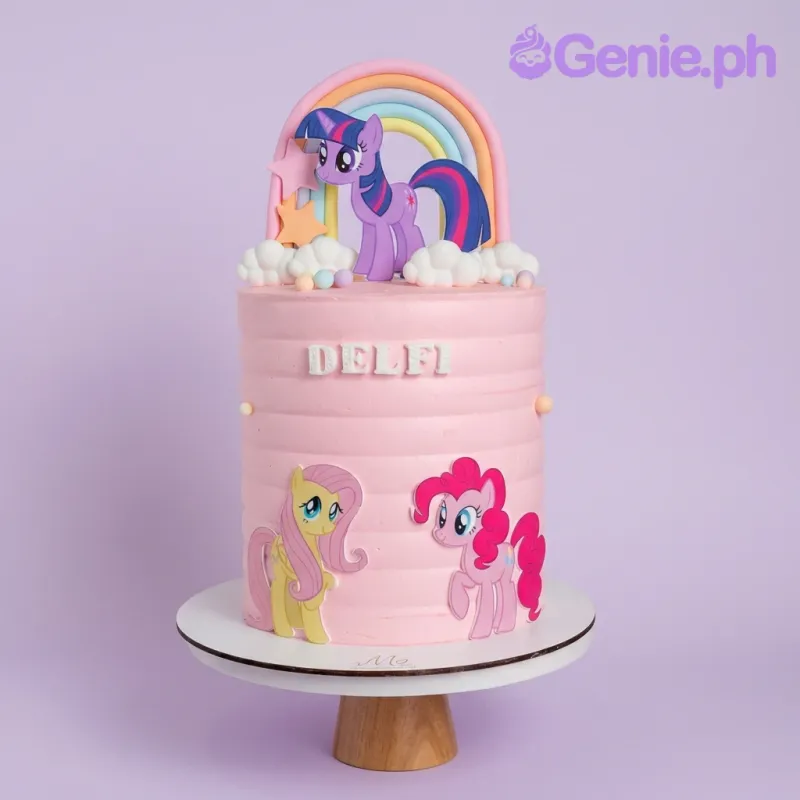 A pink and white 1-tier My Little Pony cake, featuring pony characters, a fondant rainbow, and white clouds. A pink and white 1-tier My Little Pony cake, featuring pony characters, a fondant rainbow, and white clouds.