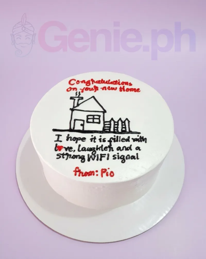 A white 1-tier cake themed around a new home, featuring a hand-drawn black icing house and red and black icing text. A white 1-tier cake themed around a new home, featuring a hand-drawn black icing house and red and black icing text.