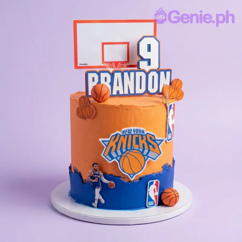 Orange single-tier basketball cake with New York Knicks logo and basketball hoop printout toppers Orange single-tier basketball cake with New York Knicks logo and basketball hoop printout toppers