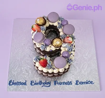 Number 9 shaped birthday cake with purple macarons, gold chocolates, strawberries, and blue piped message Number 9 shaped birthday cake with purple macarons, gold chocolates, strawberries, and blue piped message