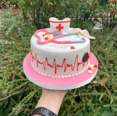 White 1-tier fondant nurse birthday cake with smooth icing, a nurse cap topper, and a stethoscope White 1-tier fondant nurse birthday cake with smooth icing, a nurse cap topper, and a stethoscope