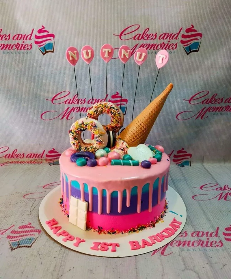 A pink and purple 1 Tier cake themed for a Nutnut Barkday, with donuts, an ice cream cone, and pink balloon toppers. A pink and purple 1 Tier cake themed for a Nutnut Barkday, with donuts, an ice cream cone, and pink balloon toppers.