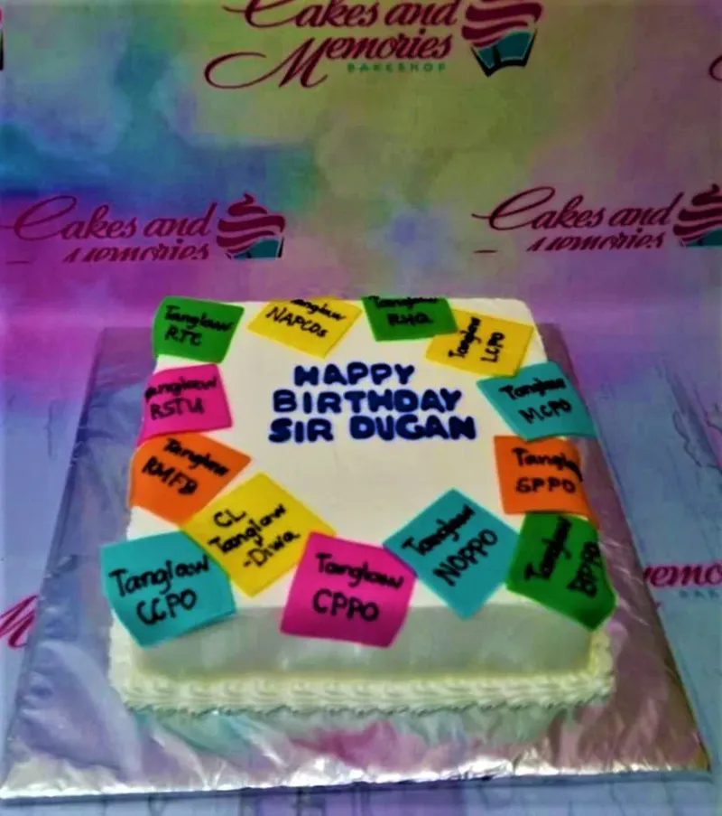 Square white birthday cake with colorful fondant post-it note decorations and blue piped message for Sir Dugan. Square white birthday cake with colorful fondant post-it note decorations and blue piped message for Sir Dugan.