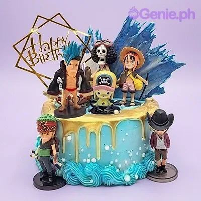 A blue 1-tier cake themed around One Piece, featuring character figurines, a 'Happy Birthday' topper, and gold drip. A blue 1-tier cake themed around One Piece, featuring character figurines, a 'Happy Birthday' topper, and gold drip.