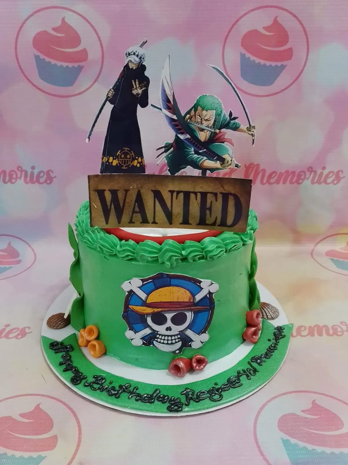 A green and white 1-tier cake themed around One Piece, with Trafalgar Law, Zoro, a Wanted sign, and a Jolly Roger. A green and white 1-tier cake themed around One Piece, with Trafalgar Law, Zoro, a Wanted sign, and a Jolly Roger.