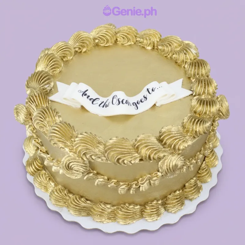 Gold 1-tier cake with a white banner topper saying And the Oscar goes to and piped gold shell borders Gold 1-tier cake with a white banner topper saying And the Oscar goes to and piped gold shell borders