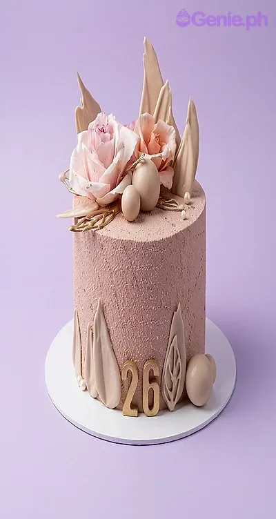 A peach and white 1-tier cake themed for a 26th birthday, featuring edible peach roses, a gold '26' topper, beige spheres, and icing leaf designs. A peach and white 1-tier cake themed for a 26th birthday, featuring edible peach roses, a gold '26' topper, beige spheres, and icing leaf designs.