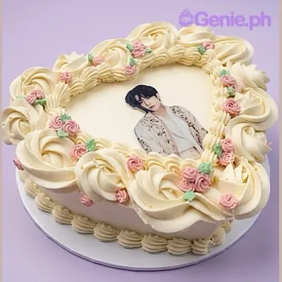 Light yellow heart-shaped birthday cake with a photo print of a person and piped rosette border Light yellow heart-shaped birthday cake with a photo print of a person and piped rosette border