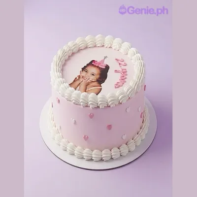 White 1-tier soft icing cake with a large edible photo print of a child, pink piped text, and small pink heart accents White 1-tier soft icing cake with a large edible photo print of a child, pink piped text, and small pink heart accents