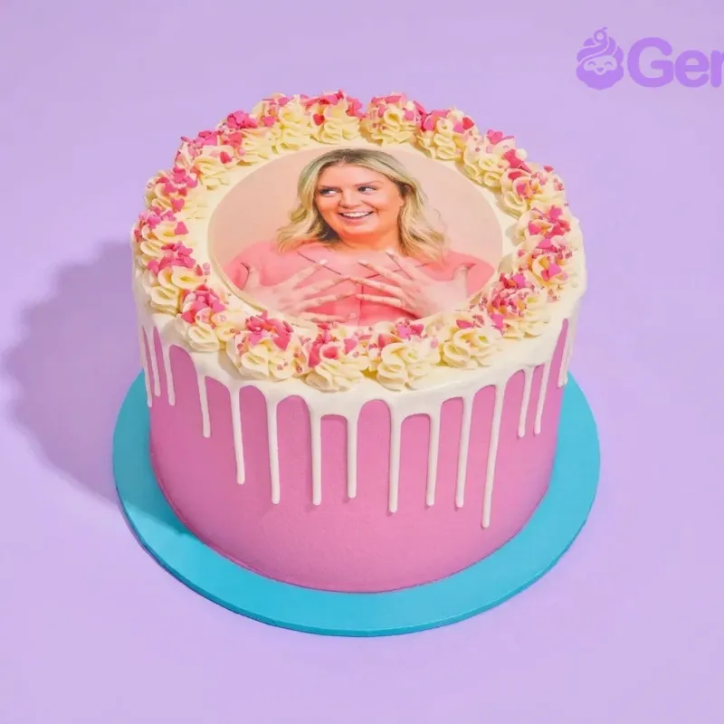 Pink 1-tier cake with white drip and edible photo of a woman on top surrounded by yellow rosettes and pink heart sprinkles Pink 1-tier cake with white drip and edible photo of a woman on top surrounded by yellow rosettes and pink heart sprinkles