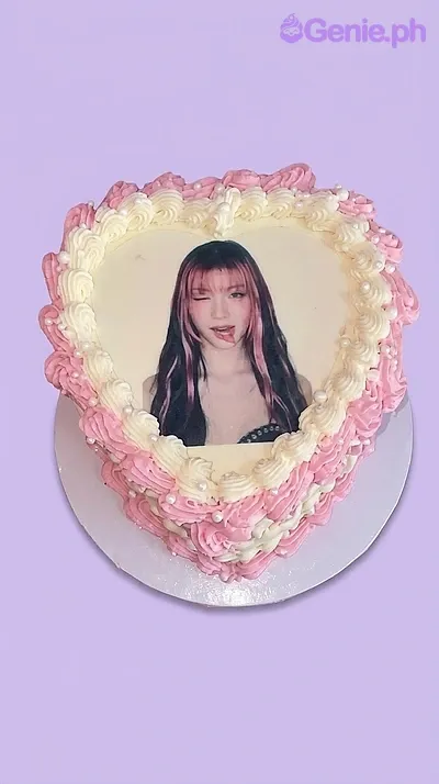 A pink and white heart-shaped 1-tier cake featuring a photo printout of a girl, ruffled icing borders, and white sugar pearls. A pink and white heart-shaped 1-tier cake featuring a photo printout of a girl, ruffled icing borders, and white sugar pearls.
