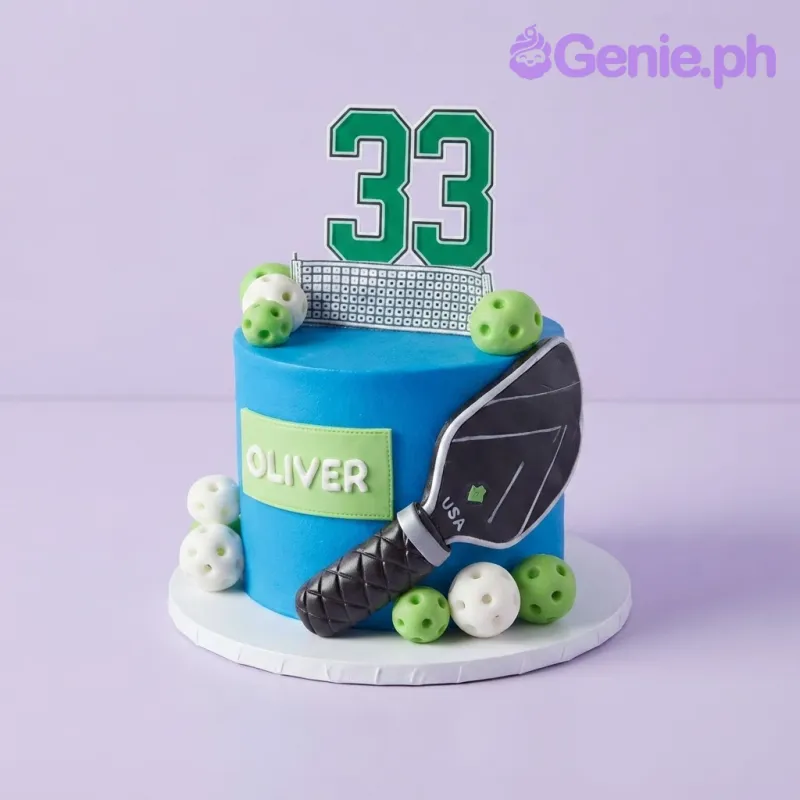 Blue 1-tier cake with a pickleball paddle, number 33 topper, and small green and white pickleball balls Blue 1-tier cake with a pickleball paddle, number 33 topper, and small green and white pickleball balls