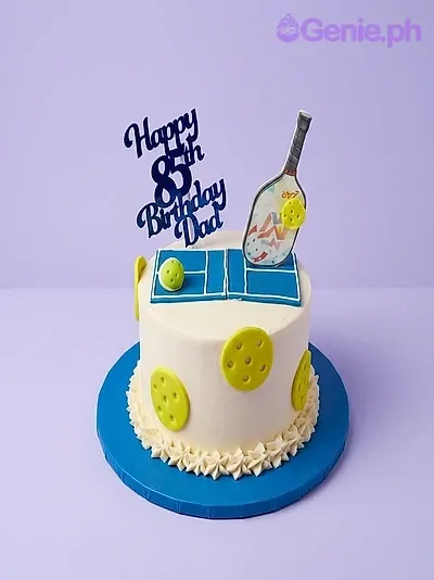 White single tier birthday cake with a pickleball court design on top and yellow ball decorations on the side White single tier birthday cake with a pickleball court design on top and yellow ball decorations on the side