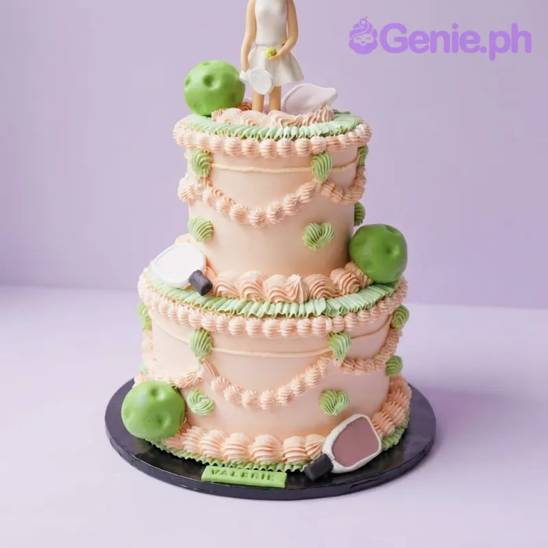Pink 2-tier soft icing cake with a pickleball player topper, green pickleball balls, and white paddle accents Pink 2-tier soft icing cake with a pickleball player topper, green pickleball balls, and white paddle accents